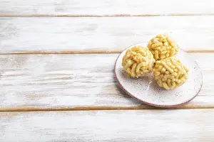 Traditional Tatar candy chak-chak made of dough and honey on a white wooden background