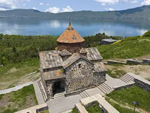 Tranquil view of a historic monastery with mountain and lake views under a clear sky
