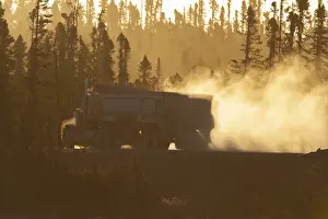 Transport truck driving on a dusty forest track
