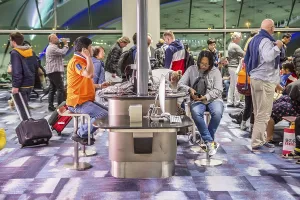 Travellers using Internet station at gate in terminal of Suvarnabhumi Airport at Bangkok