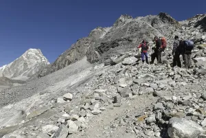 Trekking group hiking over boulder field to Cho La Pass (5330 m)