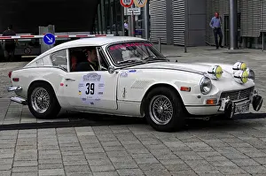 Triumph GT6, white classic car during a rally on cobblestones