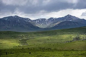 Tundra and mountain landscape with dramatic cloudy sky