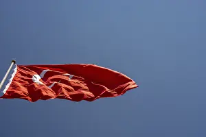 Turkish national flag with white star and moon on a pole in sky