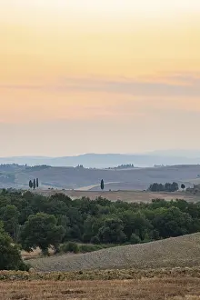 Tuscan landscape with fields and hills at sunset