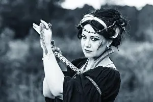 Ugly woman with snake. Witch conjure outdoors
