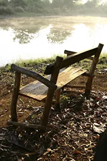 Unfinished wooden chair to enjoy the beauty of the pond looking towards the natural surrounding