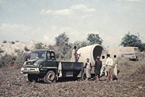 Unloading a large section of drainage pipe from a lorry for use in an irrigation project in rural Pakistan 1962