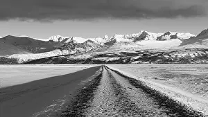 Unpaved road towards the snow-covered mountains of Skaftefellsjoell