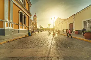 Urban view of people walking through the streets of Granada Cathedral at sunset