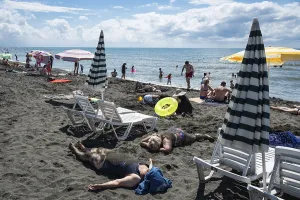 UREKI, GEORGIA - AUGUST 22, 2023: People on the beach with black sand