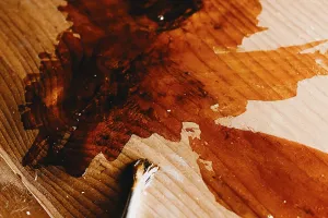 Varnish and a brush on a wooden surface with visible texture