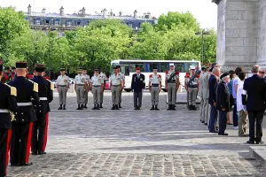 Veterans stand in a row, flanked by people in uniform