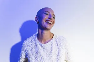 A vibrant middle-aged woman with a shaved head