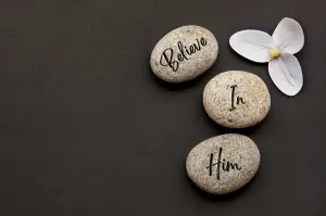 Top view of Believe In Him text engraved on zen stones with additional customizable space for text or messages