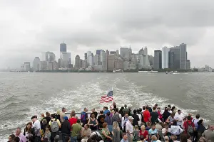 View from a boat with many people over the Hudson River towards the skyline and skyscrapers