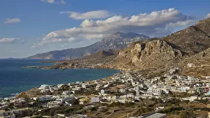 View over a coastal village against a mountain backdrop and blue sky