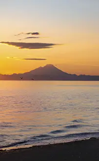 View of Cook Inlet on white mountain peaks of Mount Redoubt at sunset
