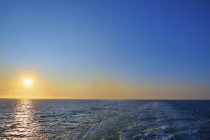 View from the cruise ship at sunrise at the stern of the ship onto the stern waves