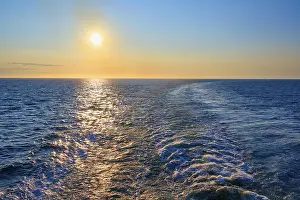 View from the cruise ship at sunrise at the stern of the ship onto the stern waves