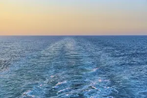 View from the cruise ship at sunset at the stern of the ship onto the stern waves