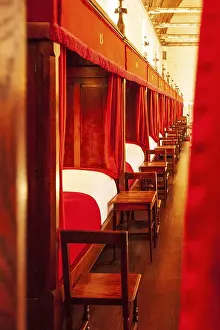 View through the curtain of the red and white hospital beds in a row in the medieval hospital Hotel Dieu