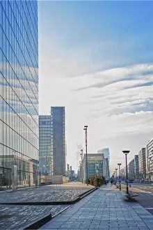 View of a district in development with modern buildings in steel and glass under the cloudy blue sky