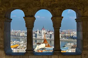 View through the facade of the Fisherman's Bastion to the Danube and the Parliament
