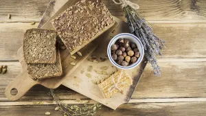 Top view whole grain bread hazelnut bowl with protein bar chopping board