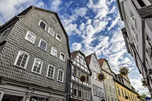 View of half-timbered houses under a vivid blue sky with decorative sun ornaments