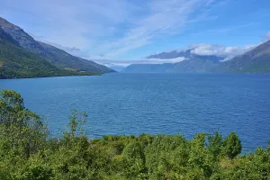 Framed Print : View of a lake framed by mountains and a blue sky