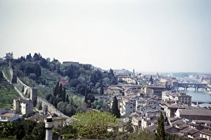View over the medieval city wall with historic buildings and the Ponte Vecchio bridge over the river Arno, Florence, Tuscany, Italy 1957