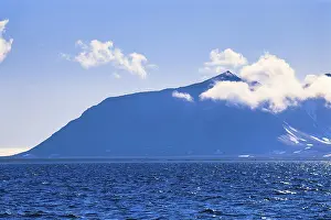 View at a mountain with clouds at Svalbard coast