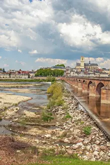 The view of Nevers on the Loire with its cathedral and the red sandstone Loire bridge in summer