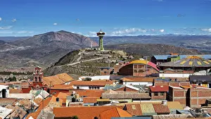 Category Cities DE Prints: View of orange roofs with a modern building and an antenna in a mountainous environment