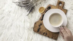 Top view person holding cup coffee with lavender dried citrus