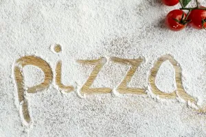 Top view pizza word written flour
