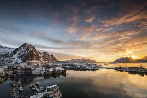 View over the port of Svolvaer on the Lofoten islands in colorful early morning sunrise in winter with snow