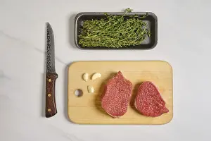 Top view of two raw beef steaks on cutting board