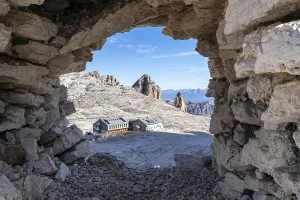 View of the rifugio Boe mountain hut through a stone window in the cairn