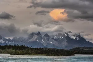 View over the river Rio Serrano to the mountain range Cuernos del Paine with cloudy sky