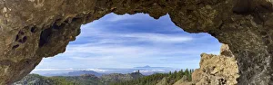 View through a rock arch to Roque Nublo and the Teide mountain peak on the neighbouring island of Tenerife