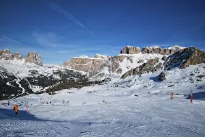 View of a ski resort piste with people skiing in Dolomites in Italy
