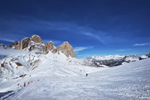 View of a ski resort piste with people skiing in Dolomites in Italy