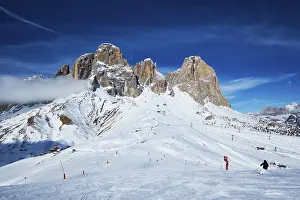 View of a ski resort piste with people skiing in Dolomites in Italy