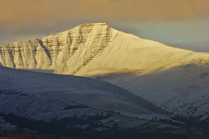 View of snow covered hills at sunrise