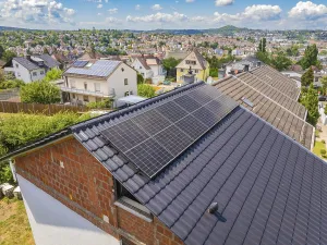 View of solar panels on a roof with a sweeping city view in the background