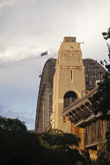 Side view of Sydney Harbour Bridge at sunset with the Australian flag