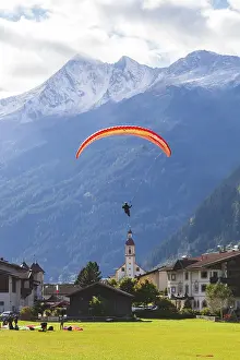 Framed Print : View of town with paraglider, meadow Framed Print : View of town with paraglider, meadow