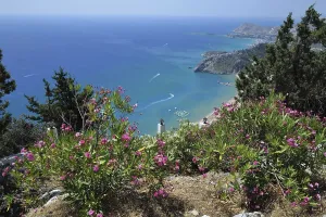 A view of Tsambika Beach and the sea with speedboats visible off the Greek island of Rhodes